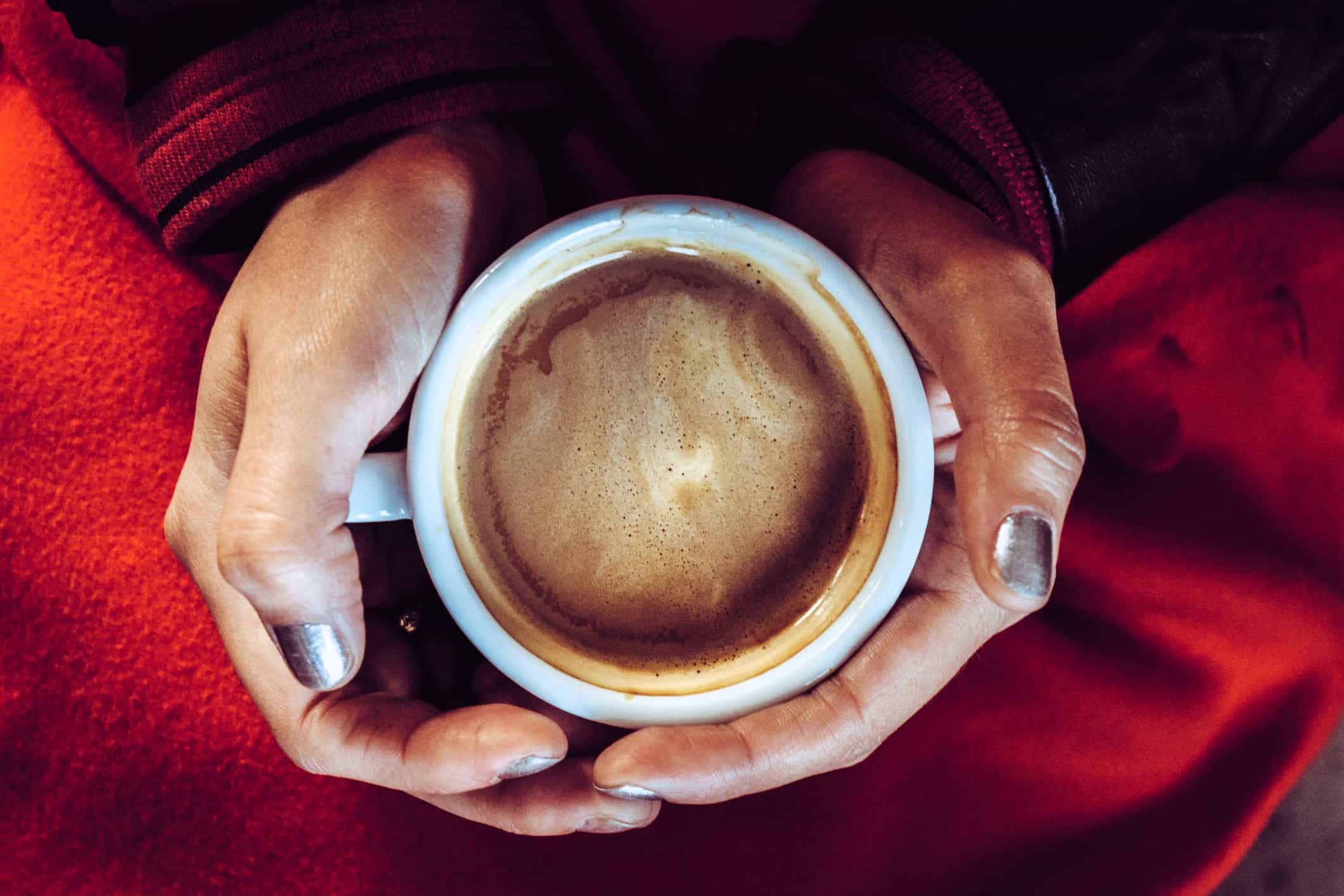 Una persona tomando una taza de mochaccino caliente.